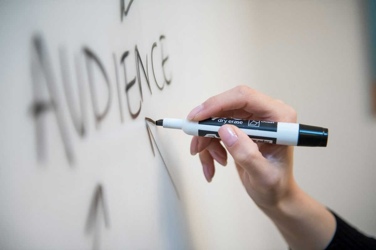 Hand writing on a whiteboard with a dry erase marker