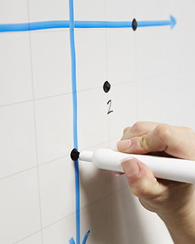 A hand drawing a clean line on a Ceramic Steel whiteboard