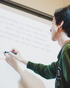 A teacher writing on a projected Ceramic Steel surface